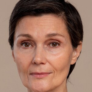 Peut inclure: Portrait rapproch&eacute; d'une femme aux cheveux courts et fonc&eacute;s. Elle a une expression neutre sur le visage, ses yeux regardant directement la cam&eacute;ra.