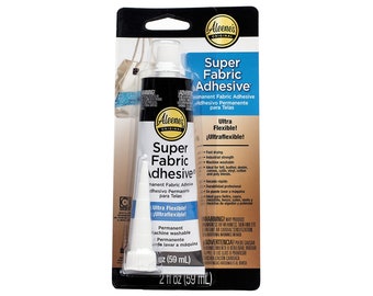 May include: A white tube of Aleene's Original Super Fabric Adhesive with a black label. The label says "Super Fabric Adhesive" and "Ultra Flexible!" The tube is 2 fl oz (59 ml).