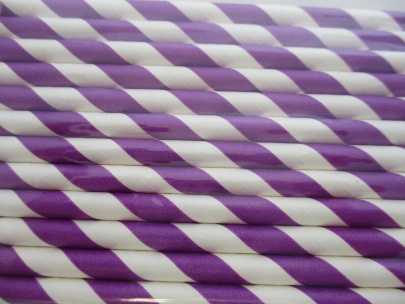May include: A close-up of a bundle of purple and white striped paper straws. The straws are arranged in a diagonal pattern.