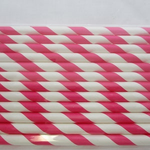 May include: A close-up of a bundle of pink and white striped paper straws. The straws are arranged in a neat stack, with the pink stripes running diagonally across the straws.