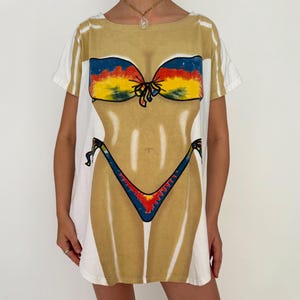 90年代ヴィンテージビキニボディグラフィックビーチカバーアップTシャツ - ワンサイズ | 楽しく着られるLAプリント、ノベルティ、レトロ、ユーモア、面白い、バケーション、スイムカバーアップ