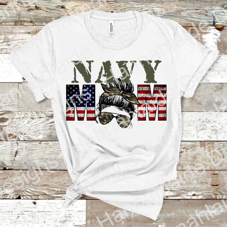 May include: White t-shirt with the text "NAVY MOM" in green letters. The "MOM" is made up of American flag stripes with a woman's face in the middle wearing a camouflage bandana and sunglasses.