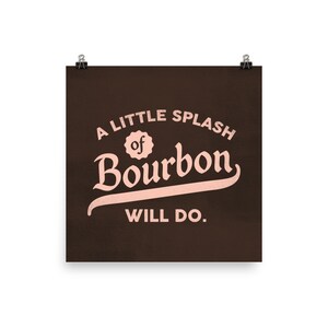 May include: A brown poster with the text "A little splash of Bourbon will do." in pink lettering.