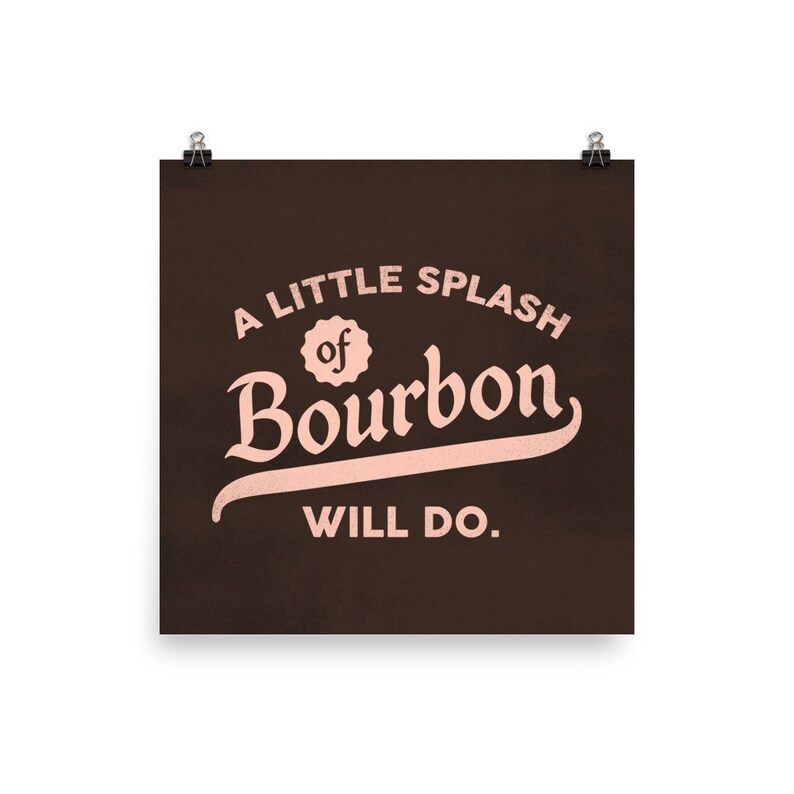 May include: A brown poster with the text "A little splash of Bourbon will do." in pink lettering.