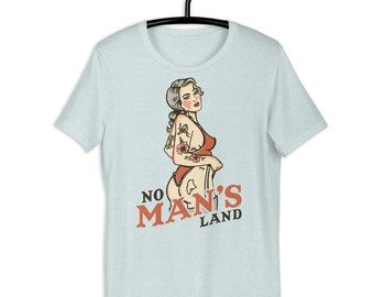 Peut inclure: T-shirt bleu clair avec une illustration vintage d'une femme tatouée et le texte "NO MAN'S LAND".