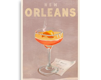 May include: A vintage-style poster with the text "NEW ORLEANS" in gold lettering on a light pink background. A cocktail glass with a pink drink and an orange garnish is in the center of the poster. A small white note with the text "I miss you xoxo" is in the bottom right corner.