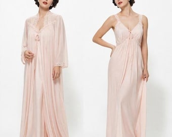 May include: A pale pink floor-length nightgown featuring a V-neckline with delicate lace trim and thin straps, paired with a matching long-sleeved sheer robe that has lace detailing along the collar and cuffs, creating a coordinated set.