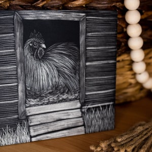 May include: A black and white drawing of a rooster in a coop doorway. The rooster is facing the right side of the image and has a white comb and wattles. The coop is made of wood and has a wooden door. The rooster is standing on a wooden step. The drawing is done in a realistic style and has a lot of detail.