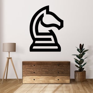 Puede incluir: Pegatina de pared de arte de línea en blanco y negro de un caballo de ajedrez. La pegatina está en una pared blanca sobre una cómoda de madera con tres cajones.