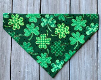 May include: Green bandana with a shamrock pattern on a dark green background. The shamrocks have a gold glitter accent.