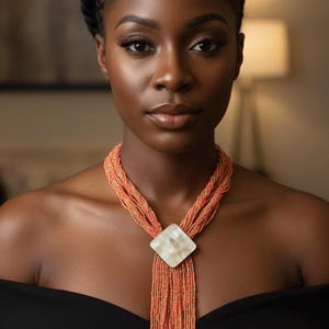 アフロセントリックな手作りの粘土、水牛の角、革で作られたイヤリング付きのユニークなネックレス。