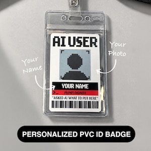 Puede incluir: Un porta credencial de plástico transparente que contiene una tarjeta blanca con el texto AI USER en fuente pixelada. La tarjeta presenta un avatar gris pixelado, una franja negra y roja con YOUR NAME y PROMPT ENGINEER, y un código de barras.