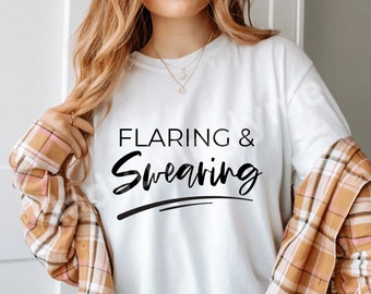 Peut inclure: T-shirt blanc avec un texte noir qui dit "FLARING & SWEARING" dans une police de caractères stylisée.