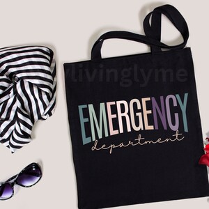 May include: Black canvas tote bag with the text "EMERGENCY department" in colorful letters. The text is in a rainbow color scheme with pink, blue, green, and purple.