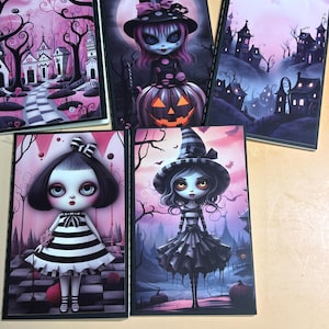 May include: Five notebooks with gothic illustrations. The covers depict spooky dolls, haunted houses, and Halloween scenes in pink, black, and white. Each notebook has a black border, perfect for spooky season.