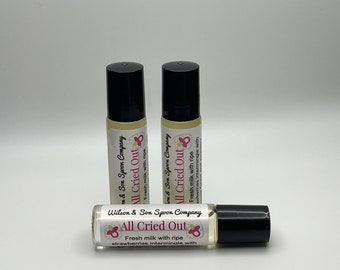 May include: Three 10 ml roll-on bottles of essential oil with black caps and white labels. The labels have pink and white text that reads "Wilson & Son Spoon Company", "All Cried Out", and "Fresh milk with ripe strawberries intermingle with".