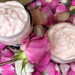 May include: Two jars of pink whipped body butter, surrounded by pink rose petals and rose quartz crystals.