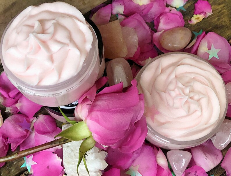 May include: Two jars of pink whipped body butter, surrounded by pink rose petals and rose quartz crystals.