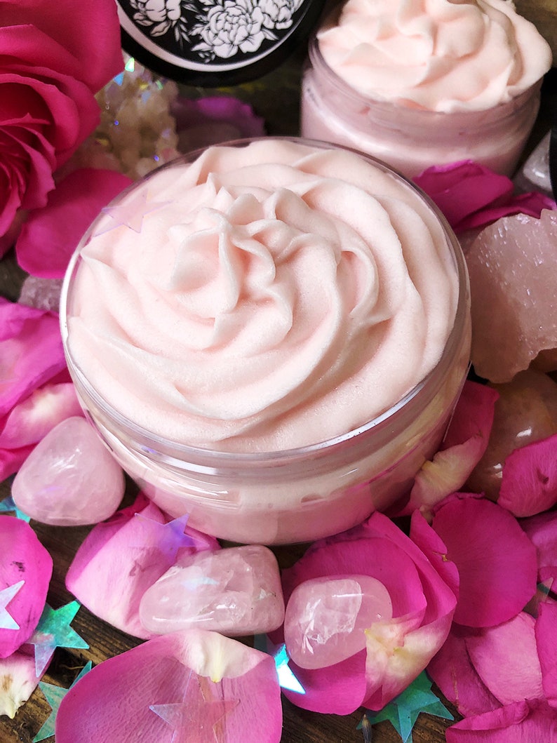 May include: Two jars of pink whipped body butter with a swirl design, surrounded by pink rose petals and rose quartz crystals.