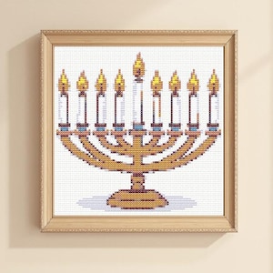 May include: Cross-stitch artwork of a gold menorah with nine lit candles, set against a white background. The menorah is in a wooden frame, with a light beige background.