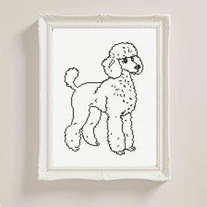 May include: A framed cross-stitch of a poodle in black and white. The dog is shown standing, with its characteristic fur style. The white frame has decorative detailing, giving the artwork a classic feel.