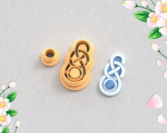 May include: A 3D printed clay cutter for earrings, featuring a knot design. The cutter is made of white plastic and has a blue center. The image also shows a smaller, round cutter.