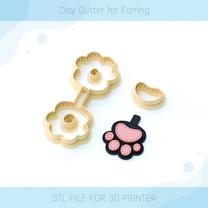 Op de afbeelding: Drie 3D-geprinte klei-uitstekers voor oorbellen. De uitstekers zijn beige en hebben de vorm van een bloem, een pootprint en een halve cirkel. De pootprint-uitsteker heeft een roze accent. De tekst "STL FILE FOR 3D PRINTER" staat onderaan de afbeelding.