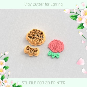 May include: Three clay cutters for earrings. Two are tan, one is a flower shape, and the other is a geometric design. The third cutter is a pink flower with green leaves. The text "Clay Cutter for Earring" and "STL FILE FOR 3D PRINTER" are visible.