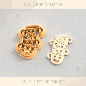 Puede incluir: Un cortador de arcilla impreso en 3D para pendientes, con forma de pila de caras de oso con diferentes expresiones. El cortador está hecho de plástico marrón y tiene un acabado liso. ARCHIVO STL PARA IMPRESORA 3D.