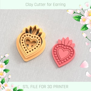 Puede incluir: Dos cortadores de arcilla impresos en 3D en forma de corazón con una corona. Los cortadores están hechos para hacer pendientes. Los cortadores están sobre un fondo de tela gris claro. ARCHIVO STL PARA IMPRESORA 3D.