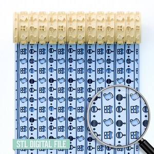 May include: A light blue patterned fabric with vertical stripes and baby-themed illustrations, including rattles and baby bottles. The text "STL DIGITAL FILE" is at the bottom. A magnifying glass shows a close-up of the pattern. A beige plastic object is at the top.