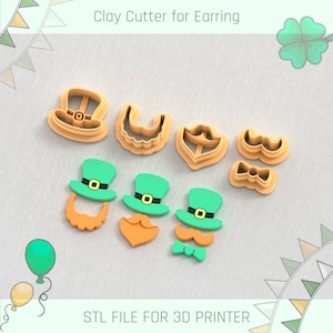 May include: Set of seven 3D printed clay cutters for earrings, featuring a leprechaun hat, beard, mustache, and bow tie. The cutters are orange, green, and brown.