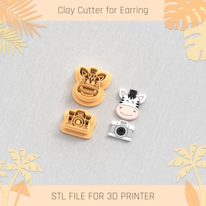May include: Three 3D printed clay cutters for earrings. The cutters are shaped like a zebra, a giraffe, and a camera. The cutters are made for use with polymer clay.