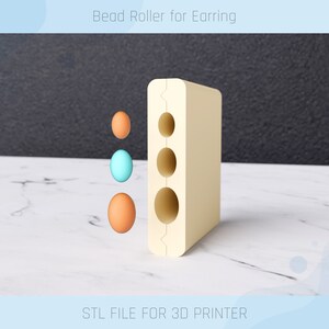 Könnte beinhalten: Ein beigefarbener 3D-gedruckter Perlenroller mit drei Löchern zum Rollen von Perlen. Der Roller ist so konzipiert, dass er perfekt runde Perlen für Ohrringe erzeugt. STL-DATEI FÜR 3D-DRUCKER.