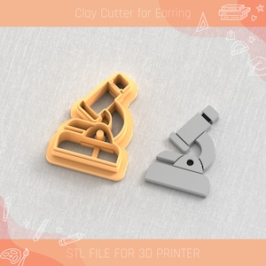 Puede incluir: Un cortador de arcilla impreso en 3D para pendientes con forma de microscopio. El cortador es de color marrón claro y el modelo impreso es gris.