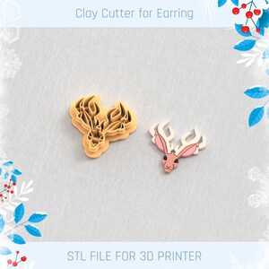 May include: A tan clay cutter for earrings in the shape of a deer head, next to a finished earring. The earring is pink and white. Text at the top says "Clay Cutter for Earring" and at the bottom "STL FILE FOR 3D PRINTER".