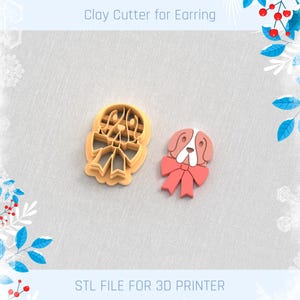 May include: A clay cutter for earrings and a finished earring. The cutter is light orange and shaped like a dog with a bow. The finished earring is pink, white, and red, also shaped like a dog with a bow. The text "Clay Cutter for Earring" and "STL FILE FOR 3D PRINTER" are visible.