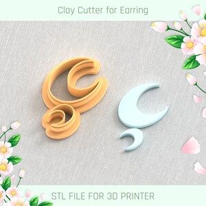 May include: Two 3D printed clay cutters for earrings. The cutters are shaped like a crescent moon and a stylized letter C. The cutters are on a light grey fabric background. STL FILE FOR 3D PRINTER.
