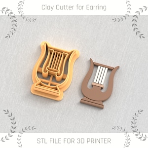 Könnte beinhalten: Zwei 3D-gedruckte Leier-förmige Tontöchter für Ohrringe. Die Ausstecher sind orange und braun. Der Text "STL FILE FOR 3D PRINTER" befindet sich am unteren Rand des Bildes.