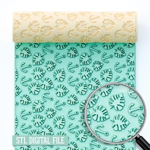 Op de afbeelding: Een lichtgele deegroller met een tropisch blad- en ankerpatroon wordt getoond boven een turquoise oppervlak met hetzelfde patroon. De woorden "STL DIGITAL FILE" staan onderaan. Een vergrootglas bevindt zich in de rechter benedenhoek.