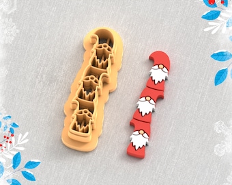 May include: A 3D printed clay cutter for earrings, shaped like a stack of gnomes. The cutter is beige and the gnomes are red with white beards and hats. The text "STL FILE FOR 3D PRINTER" is printed below the cutter.