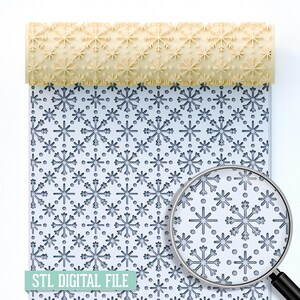 Könnte beinhalten: Eine hellbeige Teigrolle mit Schneeflockenmuster liegt über einem Blatt mit einem Schneeflocken-Design. Das Blatt hat ein sich wiederholendes Muster aus Schneeflocken und Punkten. Eine Lupe zeigt eine Nahaufnahme des Schneeflockenmusters. Der Text "STL DIGITAL FILE" befindet sich unten.
