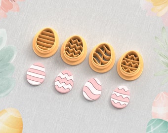 May include: Set of six 3D printed clay cutters shaped like Easter eggs with different patterns. The cutters are orange and the eggs are pink with white patterns. The text "Clay Cutter for Earring" and "STL FILE FOR 3D PRINTER" are visible in the image.