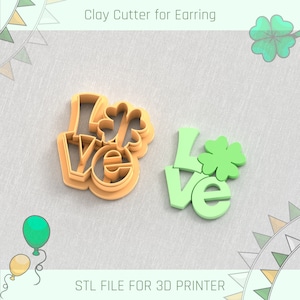 May include: A 3D printed clay cutter for earrings, shaped like the word "LOVE" with a four-leaf clover on the "O". The cutter is light brown and the clover is green. The image also shows a 3D printed version of the cutter in green.
