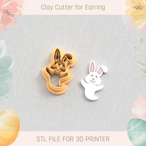 Puede incluir: Dos cortadores de galletas de conejo impresos en 3D. Uno es un conejo marrón sólido con una cara blanca y el otro es un conejo blanco con orejas rosas. El texto "Clay Cutter for Earring" y "STL FILE FOR 3D PRINTER" es visible en la imagen.