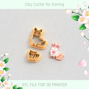 Puede incluir: Tres cortadores de arcilla para pendientes. Los cortadores tienen forma de perro corgi con detalles en forma de corazón. Un cortador es una forma completa de corgi, otro es una cabeza de corgi y el tercero es un pendiente terminado. El texto en la parte superior dice "Clay Cutter for Earring".