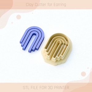 Puede incluir: Un cortador de arcilla impreso en 3D para pendientes, con forma de arco de tres capas. El cortador es beige y se muestra junto a una versión azul del cortador.