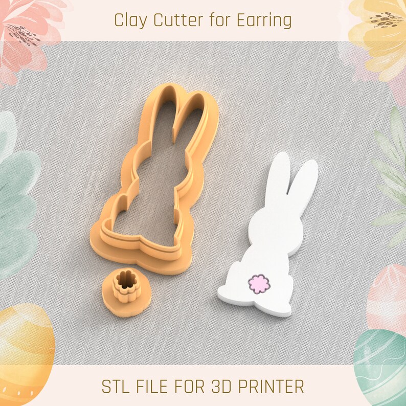 May include: A 3D printed clay cutter for earrings in the shape of a bunny. The cutter is brown and has a small, round, pink detail on the bunny's tail. The cutter is on a white fabric background. STL FILE FOR 3D PRINTER.
