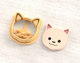 May include: Two 3D printed clay cutters shaped like a cat face. The cutters are beige and have a light brown outline. The cutters are on a light wood surface. STL FILE FOR 3D PRINTER.