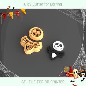 Puede incluir: Dos cortadores de arcilla impresos en 3D para pendientes. Un cortador tiene forma de cara sonriente con un contorno negro. El otro cortador tiene forma de esqueleto con alas. Los cortadores están sobre un fondo gris oscuro con un patrón de telaraña.